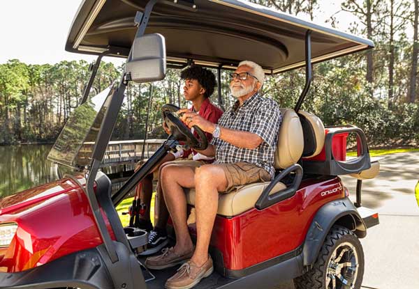 Carrinho de golfe elevado em vermelho pai e filho pescando