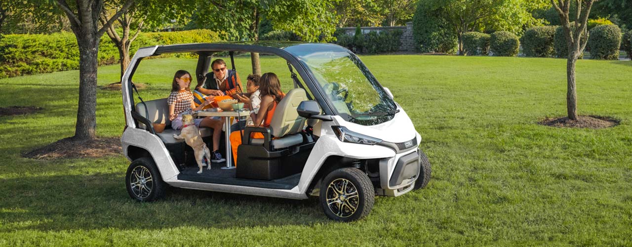 Club Car Cru NEV with family at park