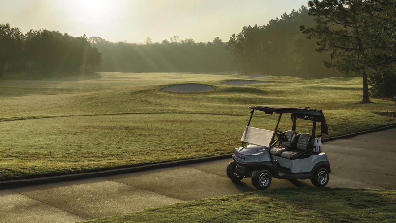 Tempo golf cart on golf course at sunrise